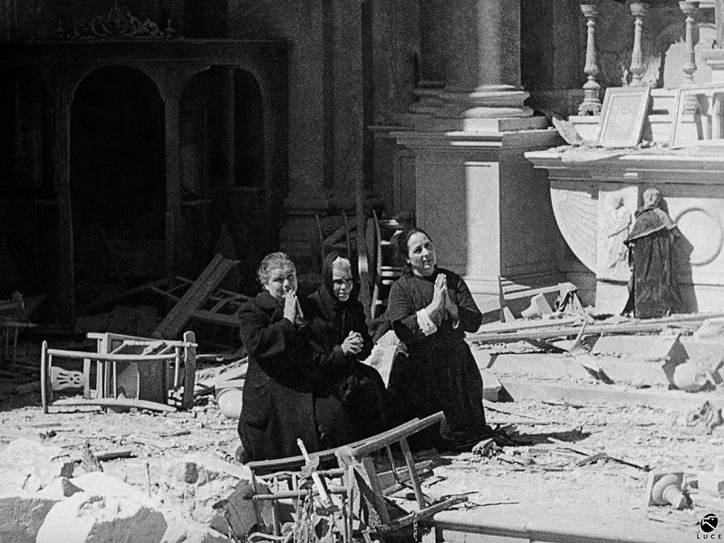 Donne pregano tra le rovine della chiesa di S. Anna, Cagliari, febbraio 1943. © Istituto Luce – Cinecittà